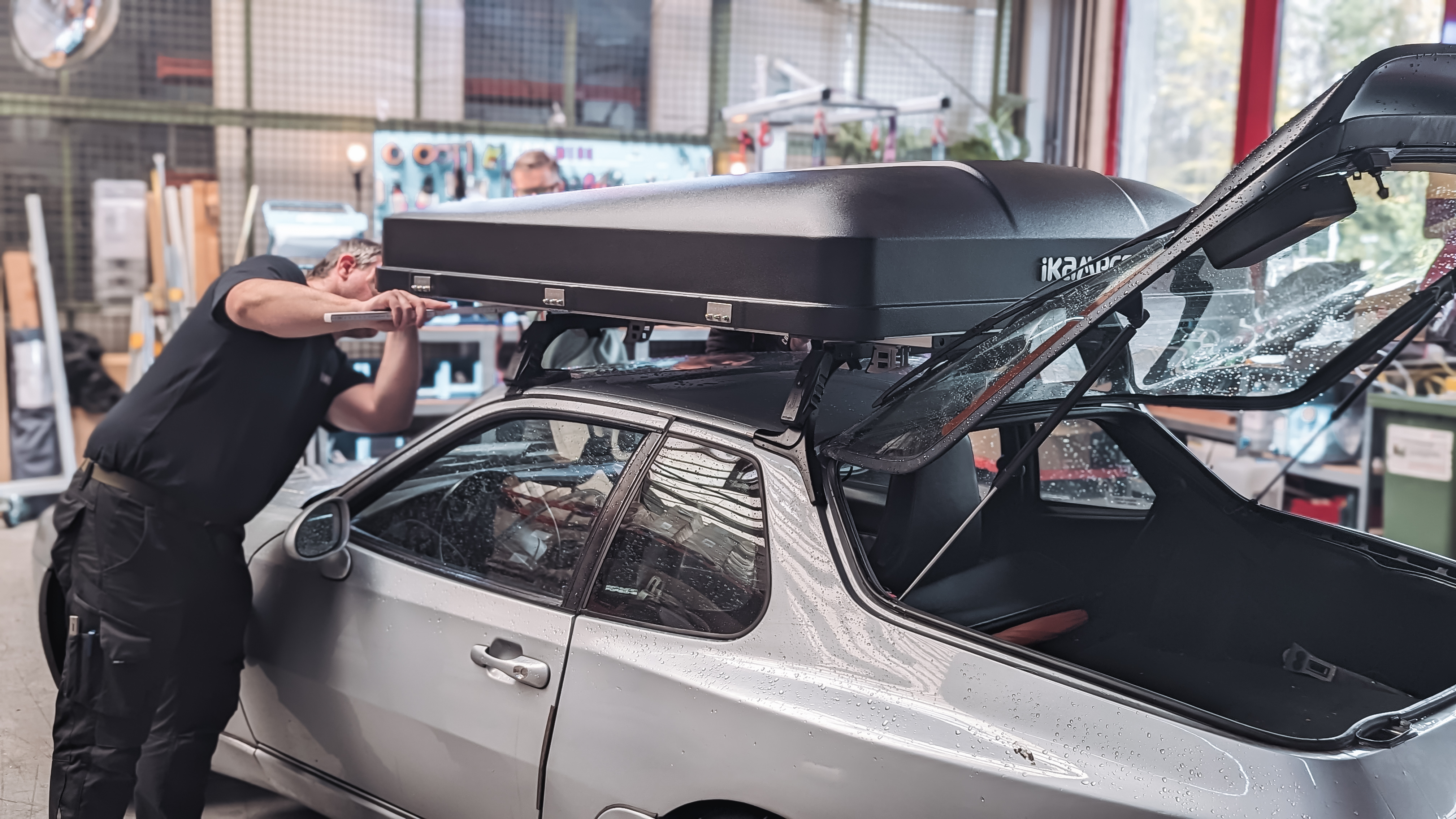 Man measures a mounted roof tent