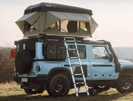 Good Vibes Hartschalen-Dachzelt auf einem hellblauen Auto in den Bergen