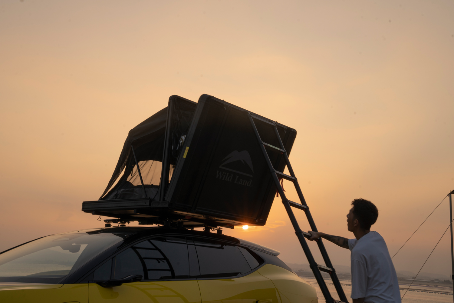 Camper climbs into his roof tent